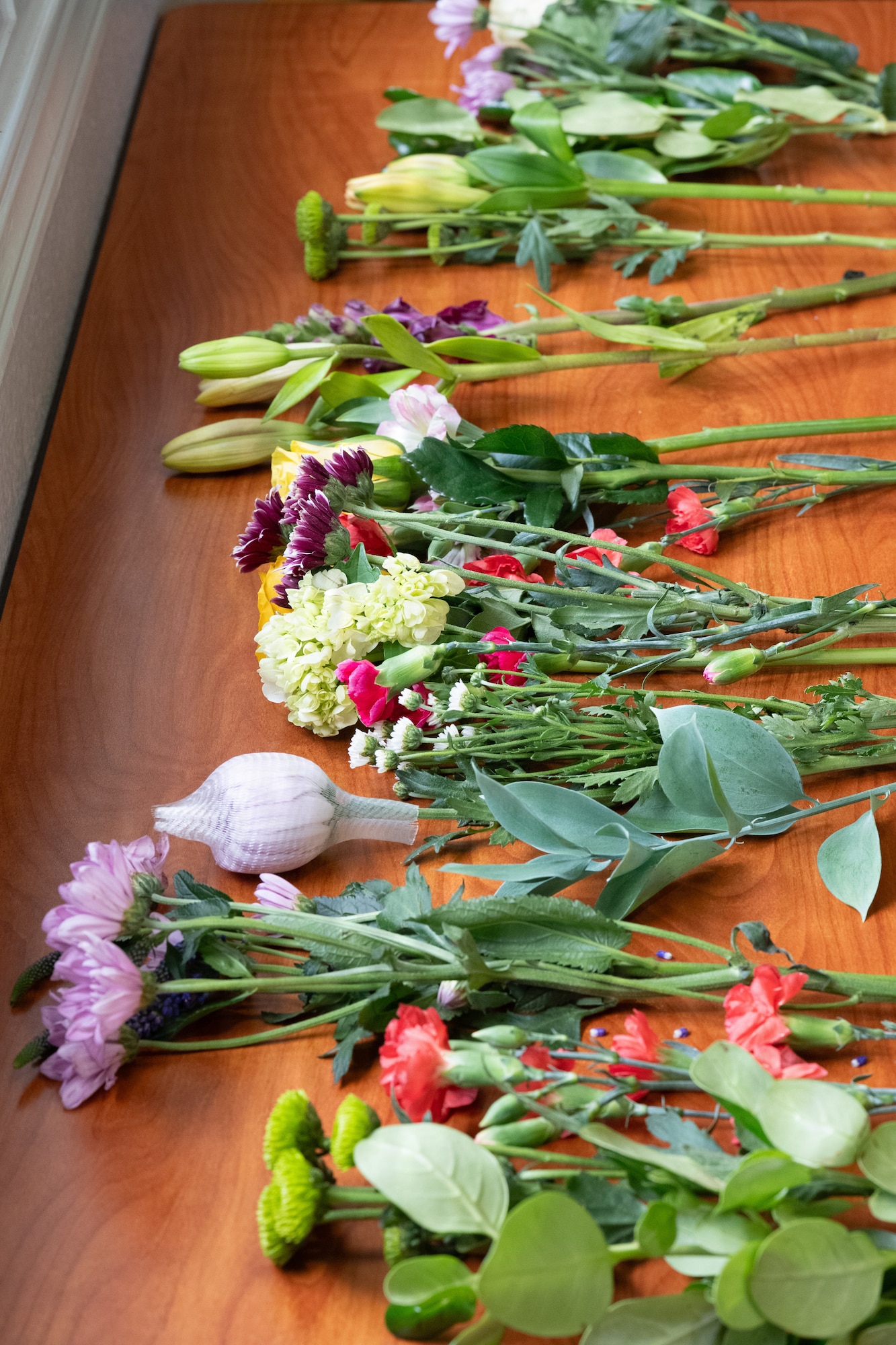 Flowers rest on a table in a row.