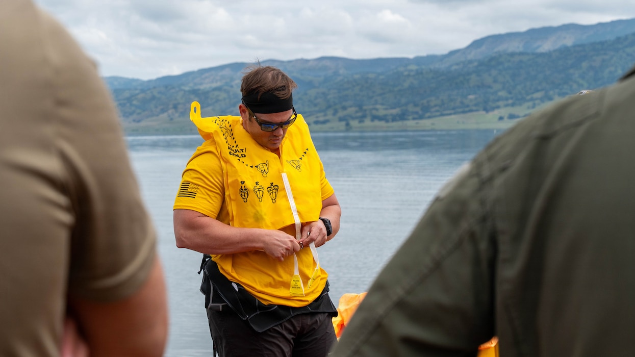 a person demonstrating how to put on a life jacket