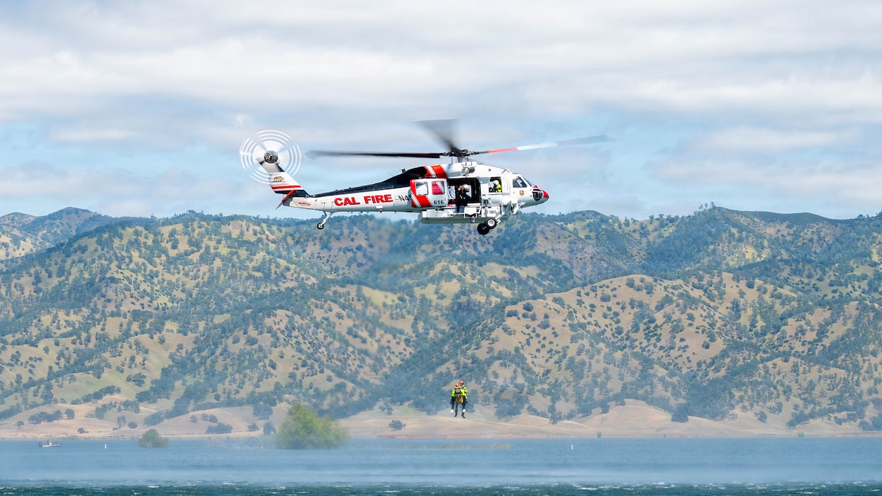 a helicopter hoisting people over water