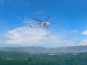 A helicopter hoists people out of water.