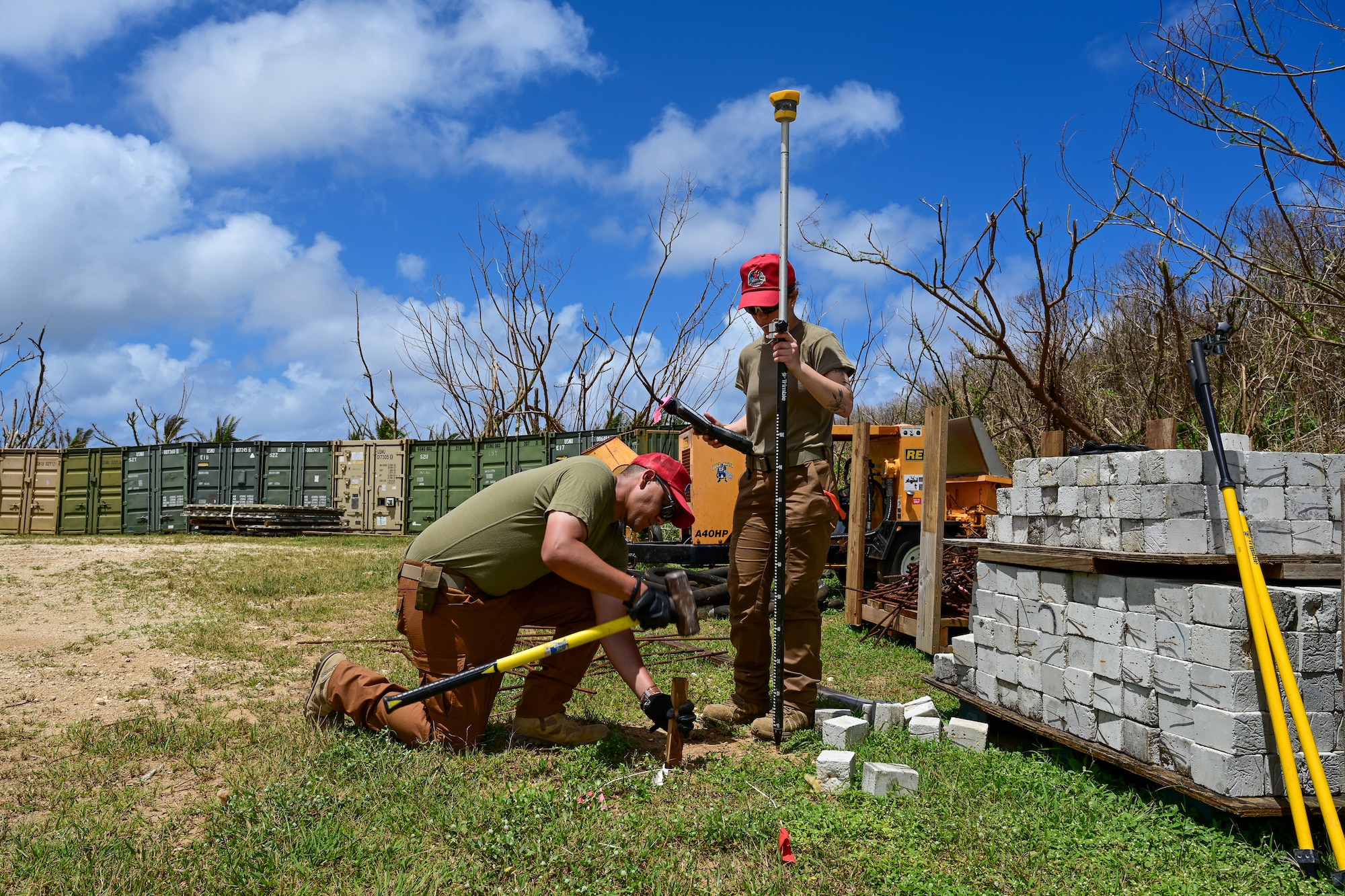 U.S. Air Force Technical Sgt. James O’Neal, engineering assistant craftsman assigned to the 513th Expeditionary Rapid Engineer Deployable Heavy Operations Repair Squadron Engineers, and Airman 1st Class Paige Finn, 513th ERHS engineering assistant journeyman, plant stakes into the ground to survey land at Camp Tinian, Tinian, Commonwealth of the Northern Mariana Islands, April 28, 2026.