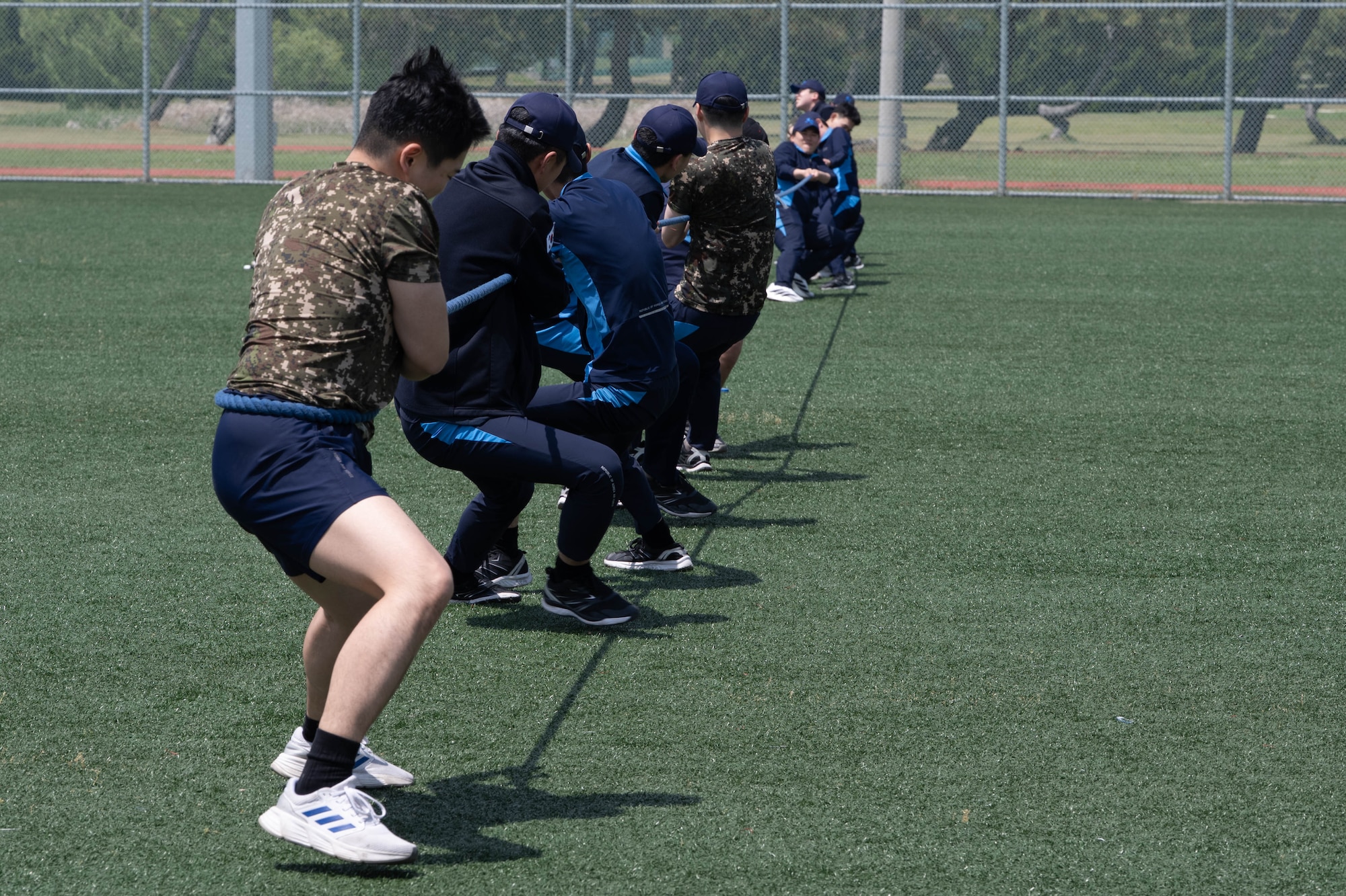Korean service members play tug-of-war.