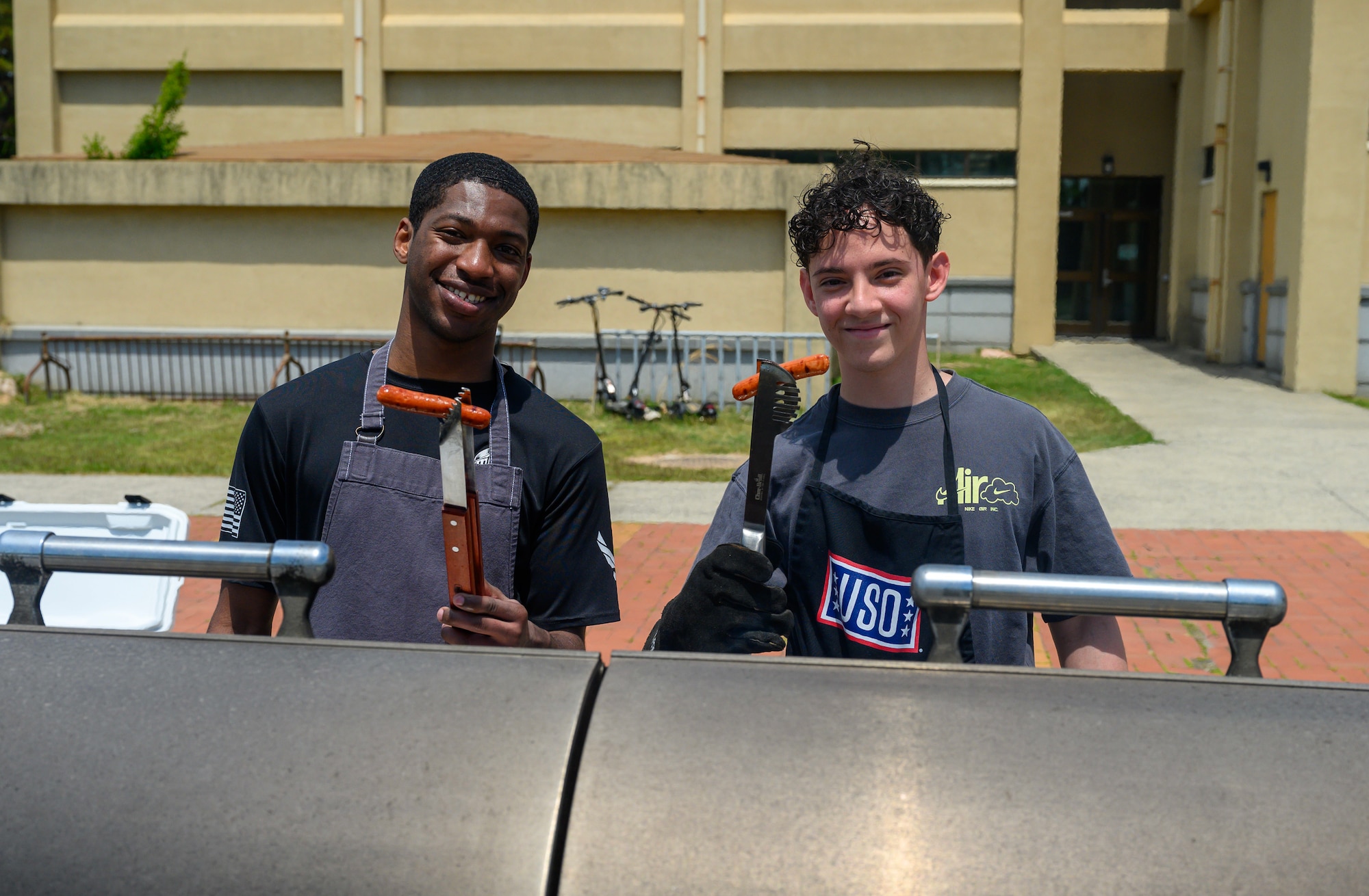 Airmen man a grill.