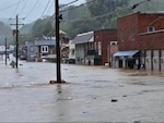 A small town main street is flooded with several feet of water.