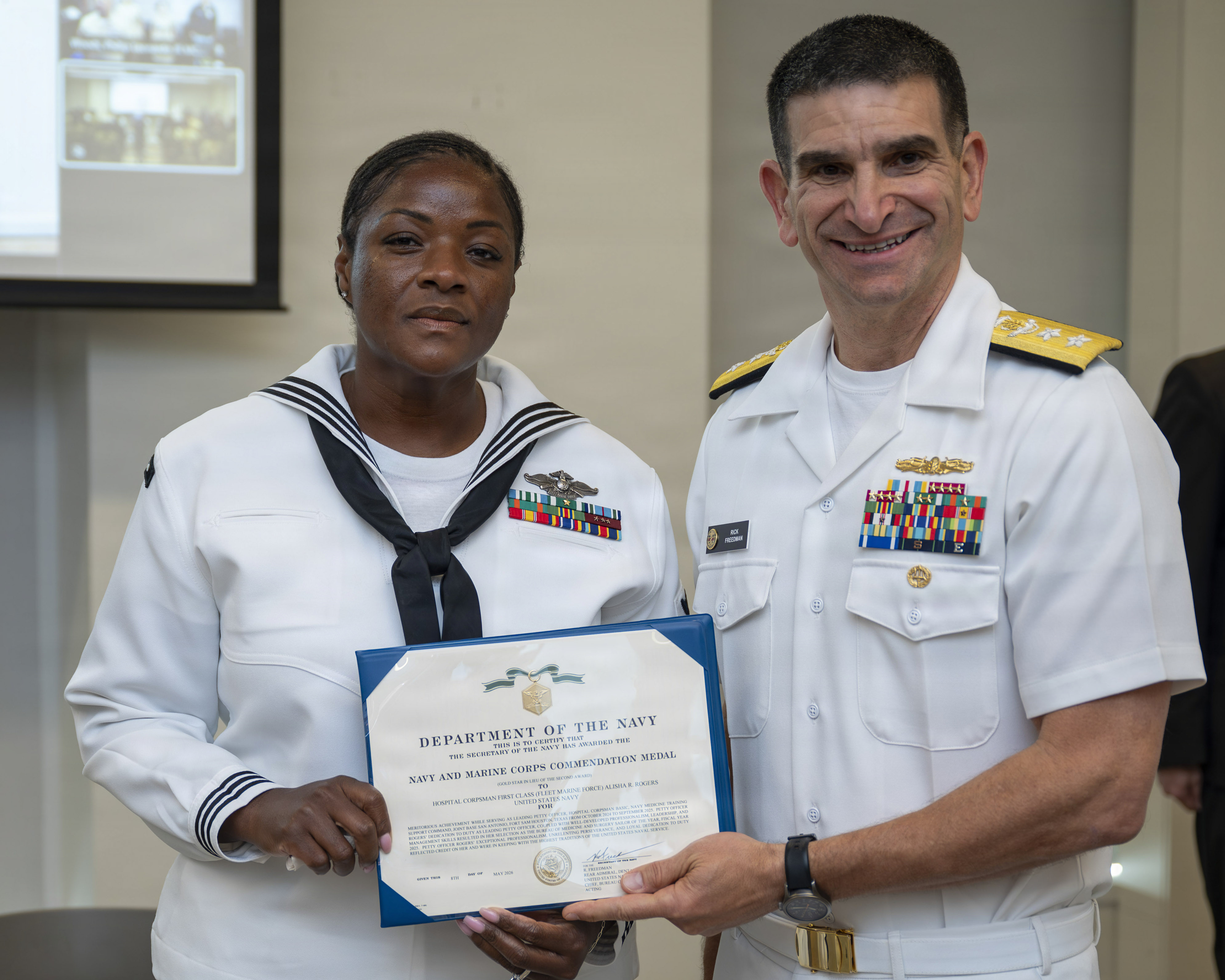 260508-N-AJ782-1122 (May 8, 2026) FALLS CHURCH, Va. Rear Adm. Rick Freedman, acting Surgeon General of the Navy and deputy chief, U.S. Navy Bureau of Medicine and Surgery (BUMED), right, presents Hospital Corpsman 1st Class Alisha R. Rogers, assigned to Navy Medicine Training Support Command  with a Navy and Marine Corps Commendation Medal during the Navy Medicine Fiscal Year 2025 Sailor of the Year Ceremony at Defense Health Headquarters, May 8. Rogers, a native of Indiana and the leading petty officer for the officer programs divisions at NMTSC, will be meritoriously promoted to the rank of chief petty officer after being recognized as the very best all-around Sailor throughout Navy Medicine.  Navy Medicine 44,000+ talented and ready forces optimize health readiness, deliver quality healthcare, and provide global expeditionary medical support to warfighters. (U.S. Navy photo by Kevin Ray J. Salvador)