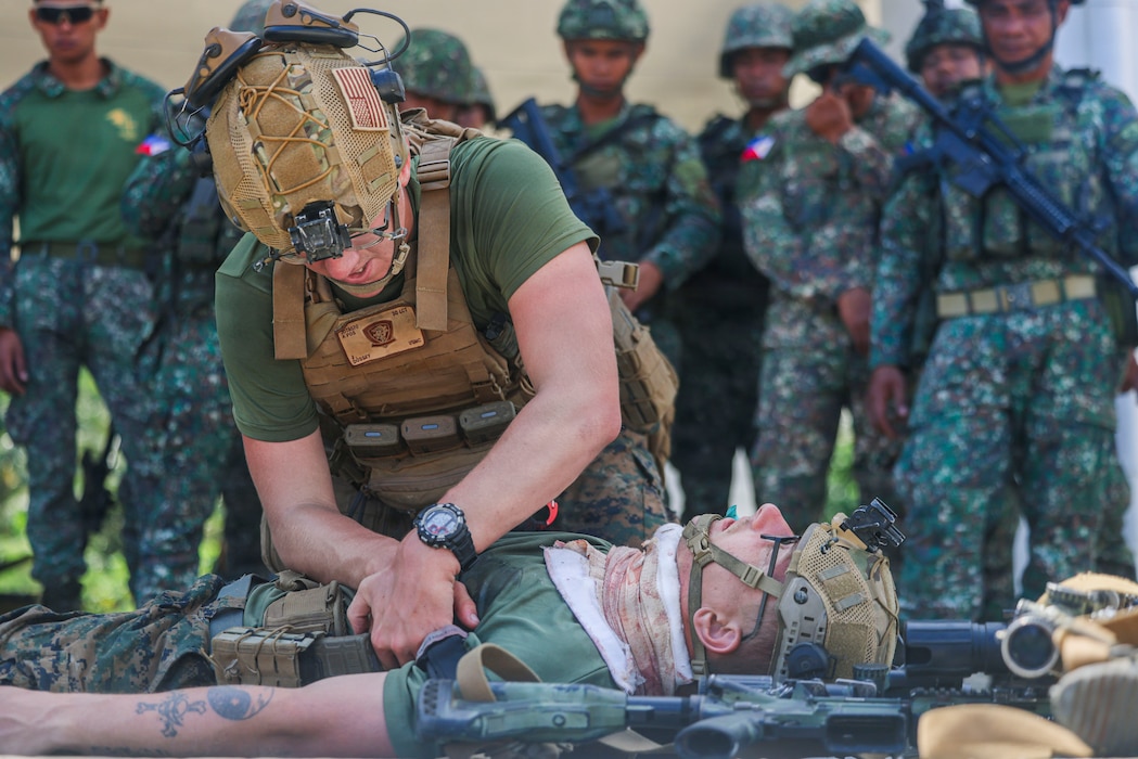 260430-M-DT244-1258 U.S. Navy Petty Officer 3rd Class Jacob Dossey, a hospital corpsman assigned to 3rd Littoral Combat Team, 3rd Marine Littoral Regiment, 3rd Marine Division, demonstrates how to perform a blood sweep on a simulated casualty during a tactical combat casualty care class as part of a maritime key terrain security operation for Exercise Balikatan 2026 at Batan, Batanes Islands, Philippines, April 30, 2026. Balikatan is a longstanding annual exercise between the Armed Forces of the Philippines and U.S. military that represents the strength of our alliance, improves our capable combined force, and demonstrates our commitment to regional peace and prosperity. Dossey is a native of Texas. (U.S. Marine Corps photo by Sgt. Iyer Ramakrishna)