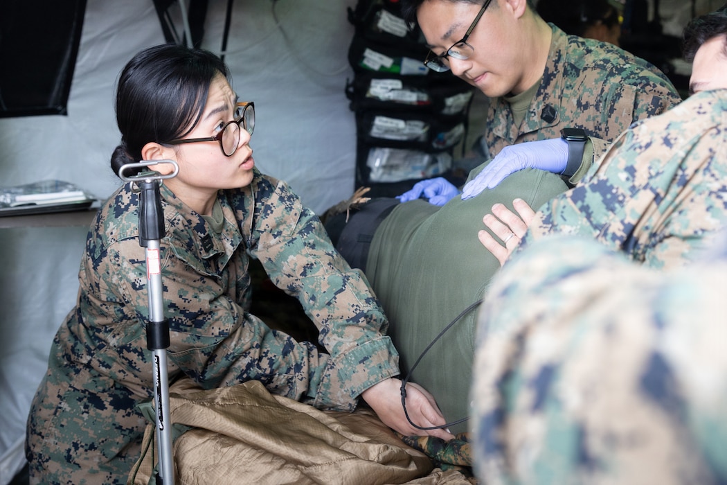 260506-M-YM562-2004 U.S. Navy Hospital Corpsman Seaman Apprentice Thi Nguyen, left, with Combat Logistics Battalion 24, Combat Logistics Regiment 27, 2nd Marine Logistics Group, checks for injuries on a Swedish Army soldier during mass casualty training as part of exercise Aurora 26 in Visby, Sweden, May 5, 2026. U.S. Marines and Sailors with 2nd MLG are participating in exercise Aurora as part of the larger U.S. Army-led Sword 26 series of linked multinational exercises, which directly supports NATO's Eastern Flank Deterrence Initiative concept, validates defense plans, builds a unified lethal force, and strengthens deterrence. Nguyen is a native of California. (U.S. Marine Corps photo by Lance Cpl. Talan Werner)
