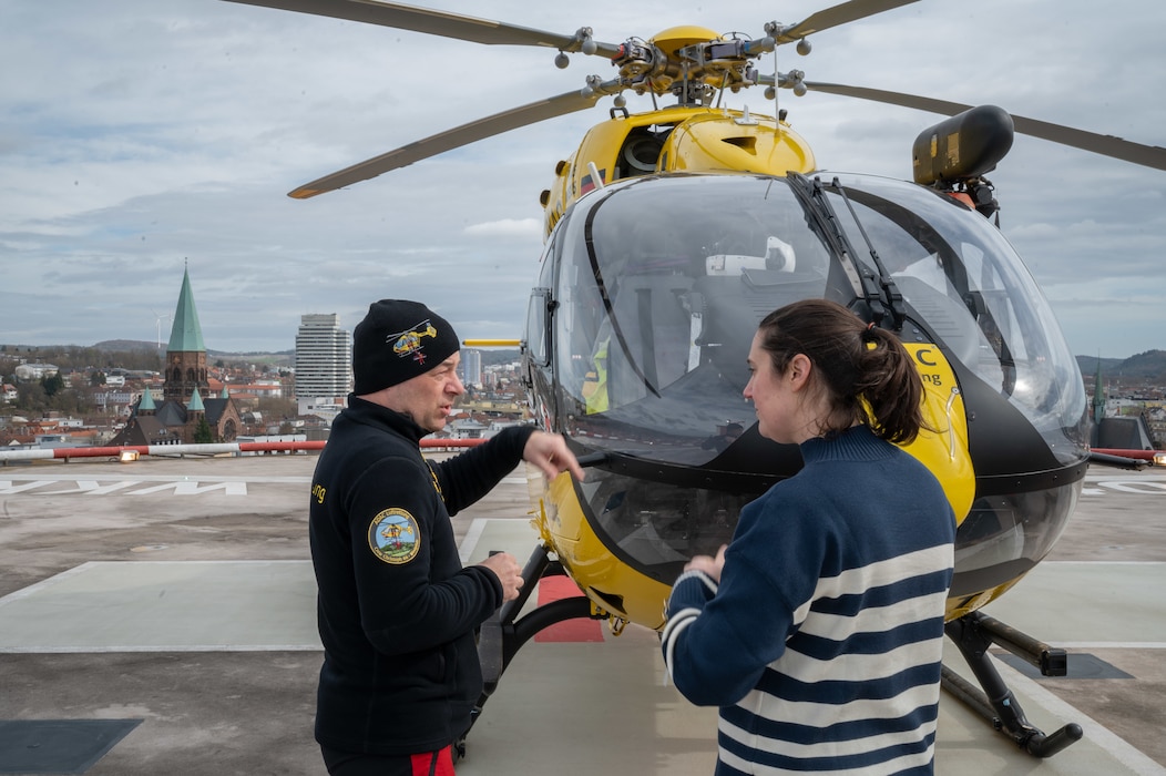 U.S. Air Force Lt. Col. Heather Corless (right), 603rd Air Operations Center deputy director, personnel recovery coordination cell, speaks to an Allgemeiner Deutscher Automobil Club (ADAC) helicopter pilot
