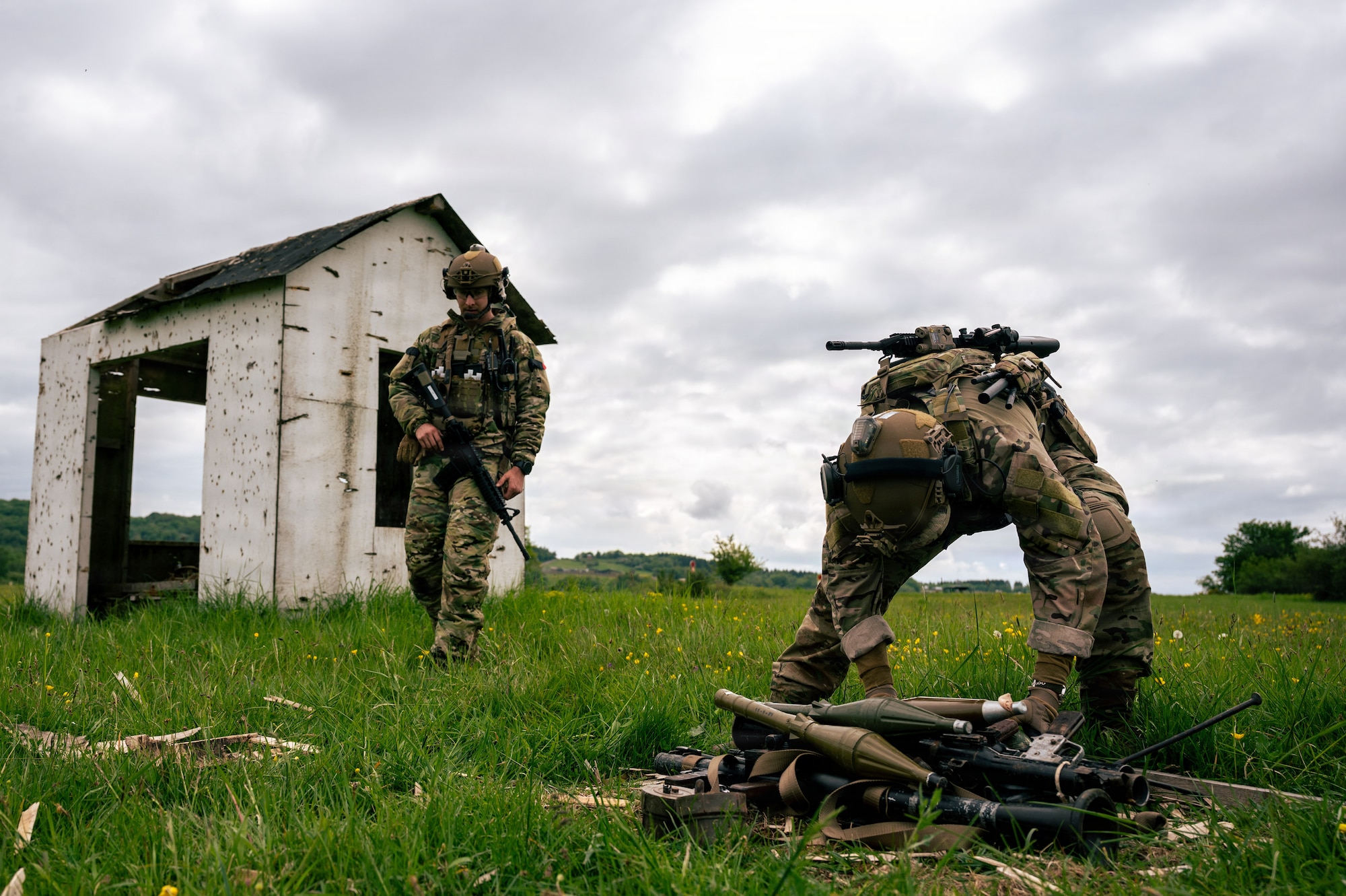 U.S. Air Force Airman 1st Class Dallin Gottfredson, right, and Senior Airman Cameroon Poe, 786th CES explosive ordnance device flight team members, secure weapons from a cache for disposal