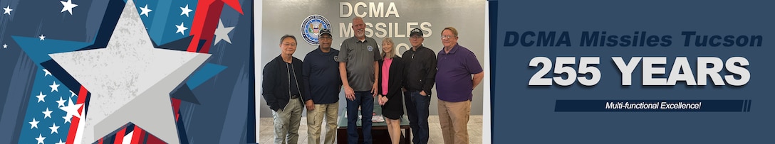 A group stands in an office lobby and poses for a picture