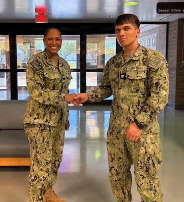 Capt. Janiese Cleckley (left), commanding officer of Navy Medicine Readiness and Training Command Twentynine Palms and director of Naval Hospital Twentynine Palms, presents Hospital Corpsman 3rd Class Mohammad Wasiq with a command challenge coin for superior customer service during a leadership visit to Navy Medicine Readiness and Training Unit China Lake and Branch Health Clinic China Lake at Naval Air Weapons Station China Lake, California, April 28, 2026. Cleckley recognized Sailors and civilian staff whose professionalism and commitment support patient care, operational readiness, and Navy Medicine’s mission of maintaining a medically ready force and ready medical force. (U.S. Navy photo by Hospital Corpsman 3rd Class Rebecca Duran)