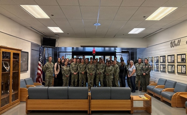 Capt. Janiese Cleckley, commanding officer of Navy Medicine Readiness and Training Command Twentynine Palms and director of Naval Hospital Twentynine Palms, and Master Chief Richard Moreno, NMRTC Twentynine Palms command master chief and Naval Hospital Twentynine Palms senior enlisted leader, pose for a group photo with Cmdr. William “PJ” Martin, officer-in-charge of Navy Medicine Readiness and Training Unit China Lake, and Sailors and staff assigned to Branch Health Clinic China Lake at Naval Air Weapons Station China Lake, California, April 28, 2026. During the visit, command leadership met with Sailors and civilian staff to discuss operational readiness, patient care, professional development, and Navy Medicine priorities supporting warfighter readiness. (U.S. Navy photo by Hospital Corpsman 3rd Class Rebecca Duran)