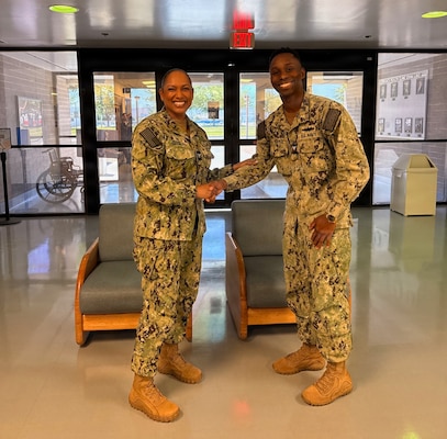 apt. Janiese Cleckley (left), commanding officer of Navy Medicine Readiness and Training Command Twentynine Palms and director of Naval Hospital Twentynine Palms, presents Hospital Corpsman 2nd Class Michael Yorks, a preventive medicine technician assigned to Navy Medicine Readiness and Training Unit China Lake, with a command challenge coin during a leadership visit to Branch Health Clinic China Lake at Naval Air Weapons Station China Lake, California, April 28, 2026. Cleckley recognized Sailors and civilian staff for their contributions to operational readiness, force health protection, and Navy Medicine’s mission of maintaining a medically ready force and ready medical force. (U.S. Navy photo by Hospital Corpsman 3rd Class Rebecca Duran)