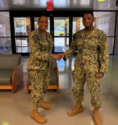 Capt. Janiese Cleckley (left), commanding officer of Navy Medicine Readiness and Training Command Twentynine Palms and director of Naval Hospital Twentynine Palms, presents Hospitalman Apprentice Christopher Thomas, a dental technician assigned to Navy Medicine Readiness and Training Unit China Lake, with a command challenge coin during a leadership visit to Branch Health Clinic China Lake at Naval Air Weapons Station China Lake, California, April 28, 2026. Cleckley recognized Sailors and civilian staff for their contributions to patient care, operational readiness, and Navy Medicine’s mission of maintaining a medically ready force and ready medical force. (U.S. Navy photo by Hospital Corpsman 3rd Class Rebecca Duran)