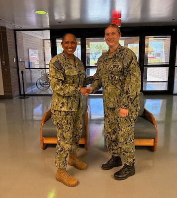 Capt. Janiese Cleckley (left), commanding officer of Navy Medicine Readiness and Training Command Twentynine Palms and director of Naval Hospital Twentynine Palms, presents Hospitalman Lillian Smith with a command challenge coin during a leadership visit to Navy Medicine Readiness and Training Unit China Lake and Branch Health Clinic China Lake at Naval Air Weapons Station China Lake, California, April 28, 2026. Cleckley recognized Sailors and civilian staff for their contributions to patient care, operational readiness, and Navy Medicine’s mission of maintaining a medically ready force and ready medical force. (U.S. Navy photo by Hospital Corpsman 3rd Class Rebecca Duran)