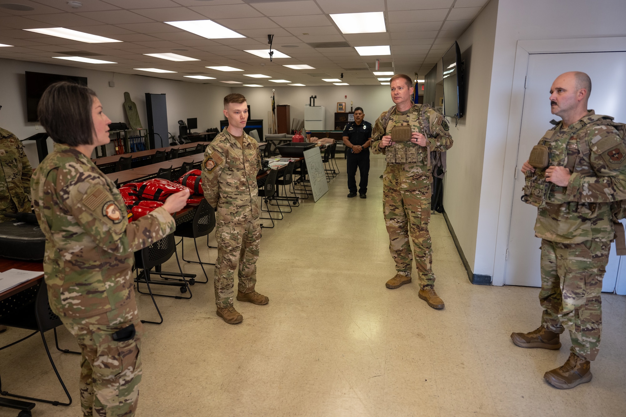 U.S. Air Force Col. Richard Kind, 97th Air Mobility Wing commander, center right, Chief Master Sgt. Jonny Adams, right, 97th AMW command chief, and 97th Security Forces Squadron Defenders discuss tactical gear at Altus Air Force Base, Oklahoma, May 7, 2026. The briefing gave the command team a closer look at the equipment Defenders use to support law enforcement, force protection and emergency response operations across the installation. (U.S. Air Force photo by Airman 1st Class Nathan Langston)