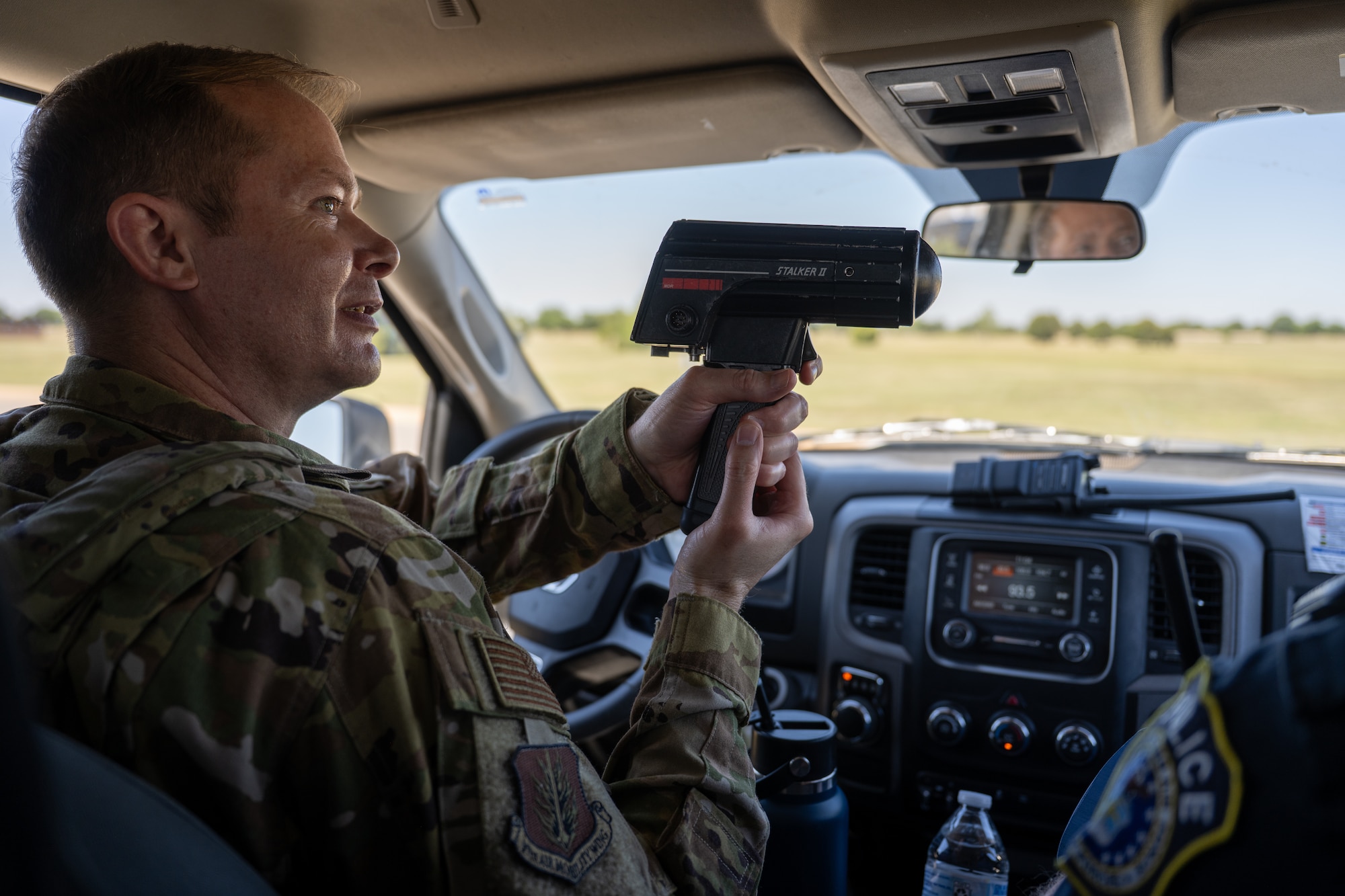 U.S. Air Force Col. Richard Kind, 97th Air Mobility Wing commander, uses a speed detection device during a 97th Security Forces Squadron patrol ride-along at Altus Air Force Base, Oklahoma, May 7, 2026. The demonstration highlighted how Defenders conduct traffic enforcement and support daily law enforcement operations across the installation. (U.S. Air Force photo by Airman 1st Class Nathan Langston)