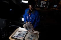 a person inspects newspapers