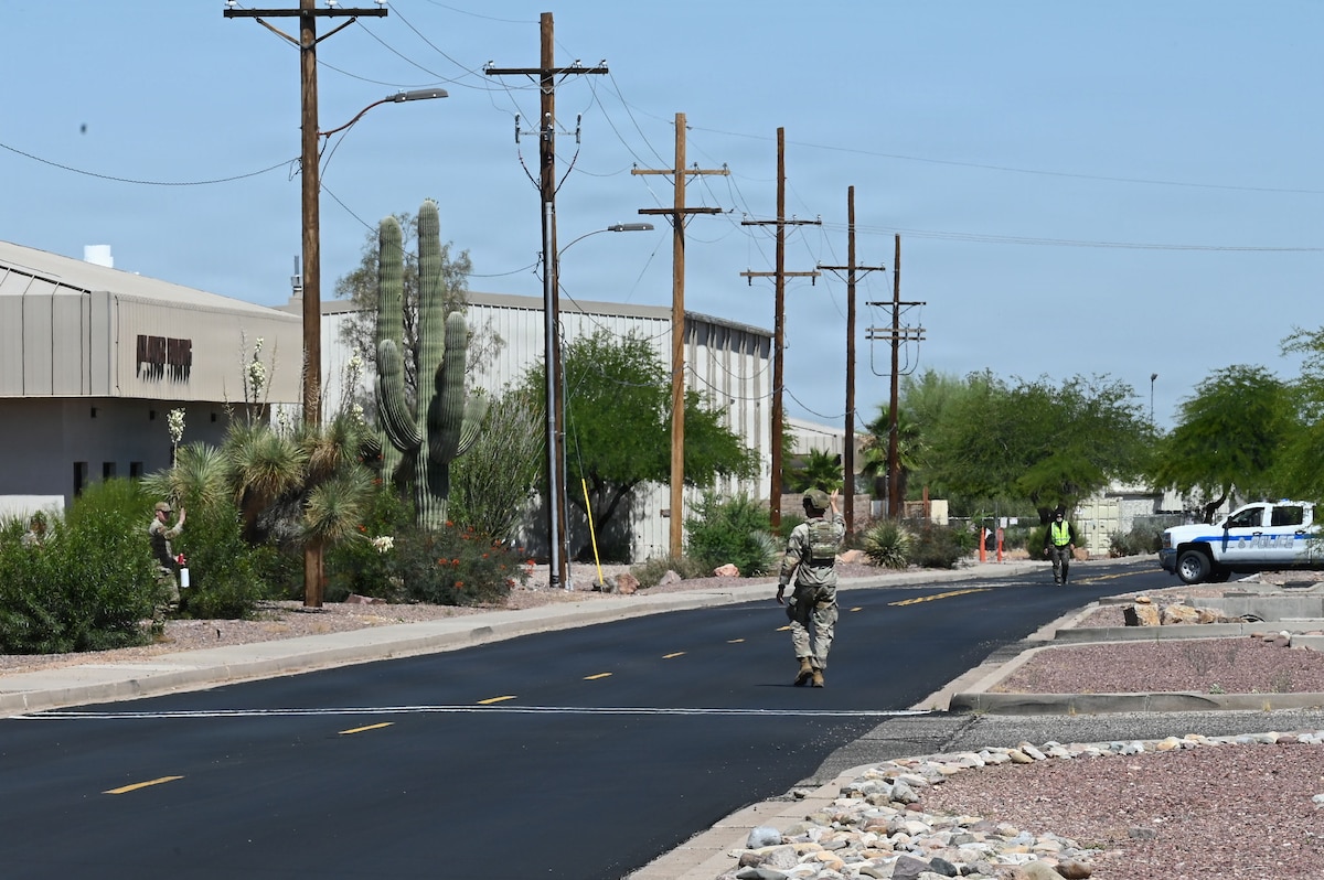 U.S. Air Force Staff Sgt. Trevor Frank, 355th Security Forces Squadron military working dog trainer, directs evacuated service members away from a simulated vehicle-borne improvised explosive device during Mosaic Lightning 26-2 at Davis-Monthan Air Force Base, Arizona, May 8, 2026. Once MWD Oko alerted his handler about the presence of explosives in the vehicle, the team contacted the 355th Civil Engineer Squadron explosive ordnance flight for further examination. During ML 26-2, readiness began behind the scenes. Mission support functions like logistics, medical care, civil engineering, and base operations are the backbone of the Air Force’s ability to adapt, overcome, and dominate in every domain. (U.S. Air Force photo by Staff Sgt. Kahdija Slaughter)