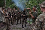Suriname Armed Forces Sgt. First Class Alvaro Ronoreso teaches survival techniques to U.S. Soldiers and Airmen, as well as Suriname Armed Forces members, during Operation Rumble in the Jungle at Ayoko, Suriname, April 17, 2026. The austere environment survival exchange is designed to test the forces' ability to operate together in demanding jungle conditions, marking 20 years of security cooperation between the South Dakota National Guard and Suriname through the Department of War National Guard Bureau State Partnership Program. Photo by Senior Airman Kyle St. Pierre.