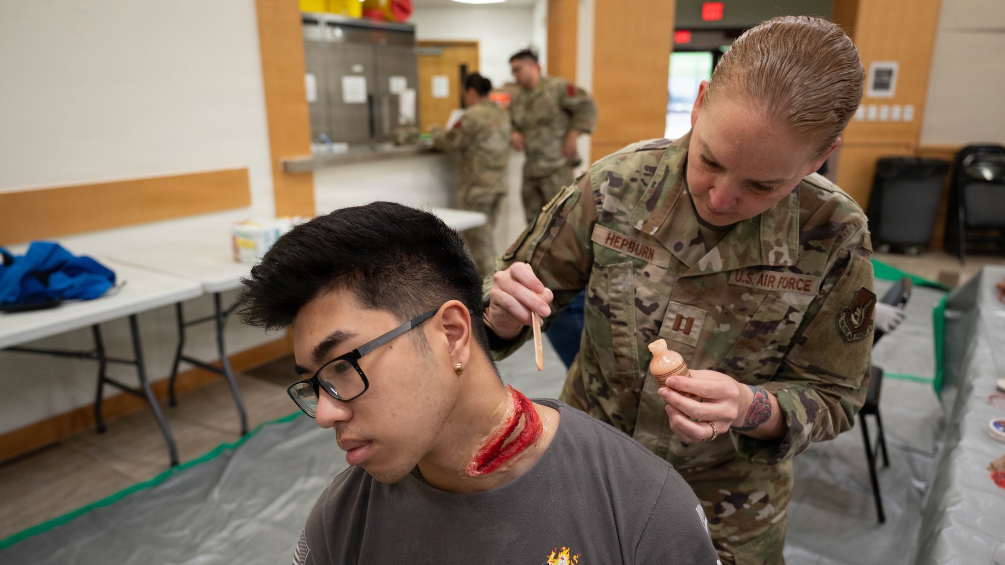 U.S. Air Force Capt. Racheal Hepburn, 51st Healthcare Operations Squadron clinical nurse, applies moulage to a participant before an active shooter scenario during exercise Mustang Rodeo 26-2 at Osan Air Base, Republic of Korea, May 12, 2026. Mustang Rodeo 26-2 is a smaller scale training event designed to strengthen contingency response skills through focused, scenario-based training. (U.S. Air Force photo by Airman 1st Class Megan Cusmano)