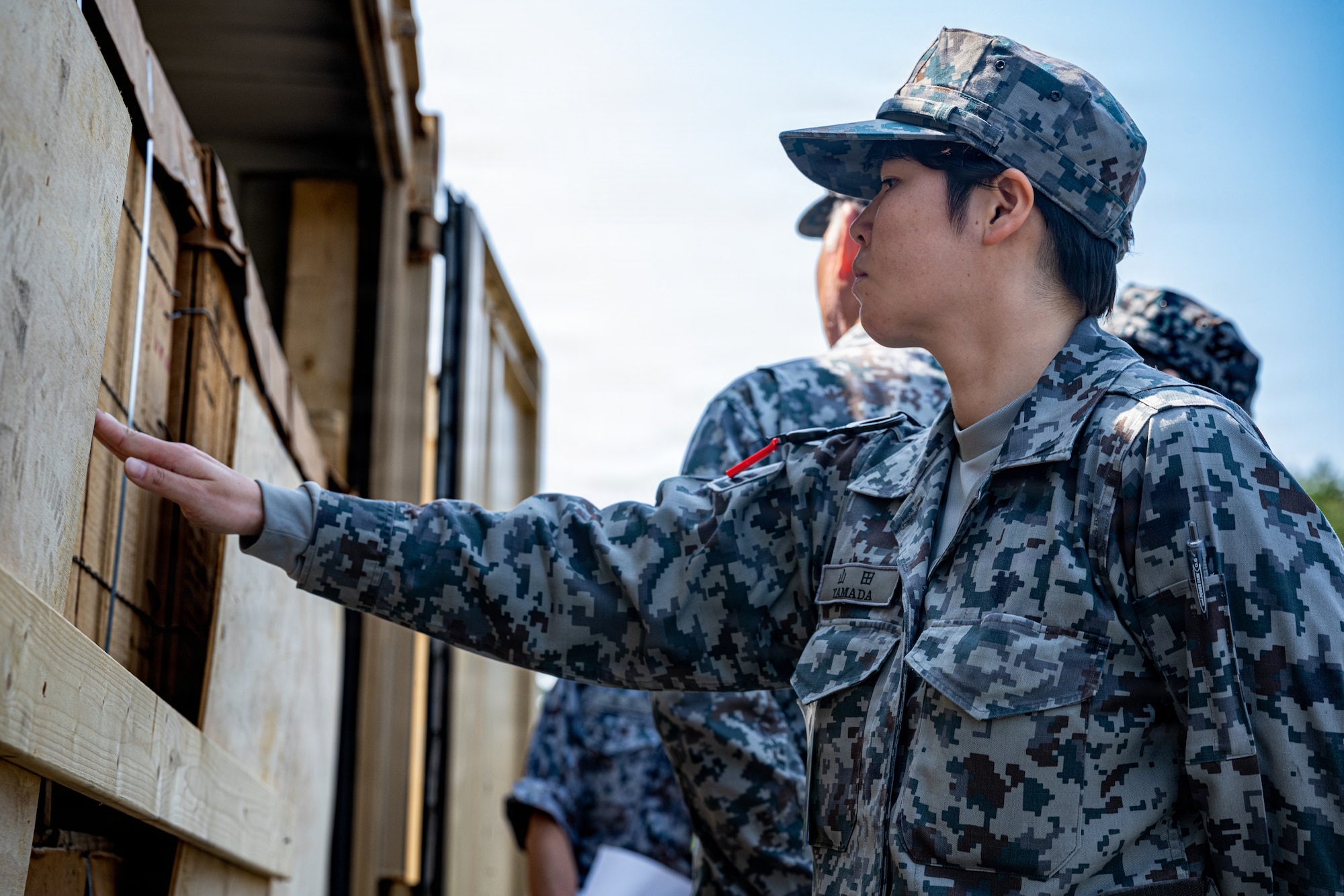 Japan Air Self-Defense Force Airman 1st Class Mizuki Yamada, 3rd Air Wing security guard and transportation squadron, inspects a storage container during an immersion tour.