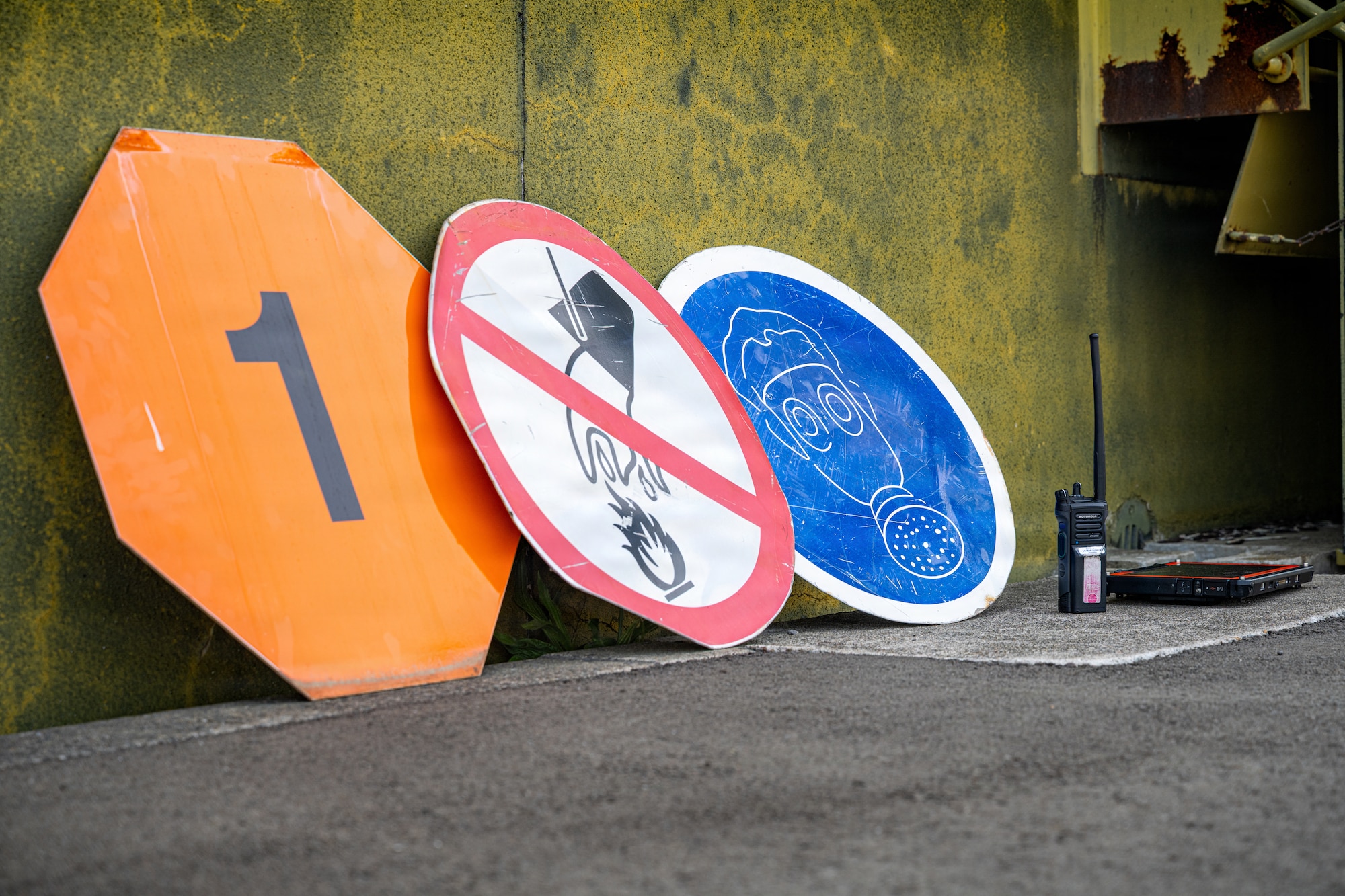 Common munitions warning signs are displayed in front of a storage igloo during an immersion tour.