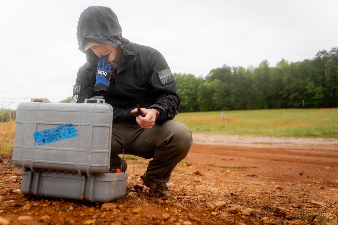 A United States Secret Service Special Agent, prepares wires for detonation on Marine Corps Base Quantico, May 11, 2026. This exercise showcased various explosive threats, including car bombs, pressure cooker bombs, explosive-vests, and C4, to help Secret Service and Department of Homeland Security employees better recognize and understand their effects. (U.S. Marine Corps photo by Cpl. Joshua Munsen)