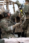 An Alaska Air National Guardsman assigned to the 212th Rescue Squadron, 176th Wing, prepares an intravenous line while responding to a simulated mass-casualty incident during a full mission profile exercise at Joint Base Elmendorf-Richardson, Alaska, Oct. 13, 2021. The busiest rescue force in the Department of War, the 212th Rescue Suadron provides elite pararescuemen and combat rescue officers that are uniquely skilled in integrating air and ground capabilities to carry out the Alaska National Guard's 176th Wing’s wartime and peacetime personnel recovery missions. Photo by Alejandro Peña.