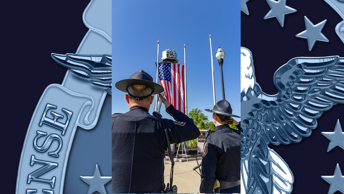 Two police officers face American flag and salute