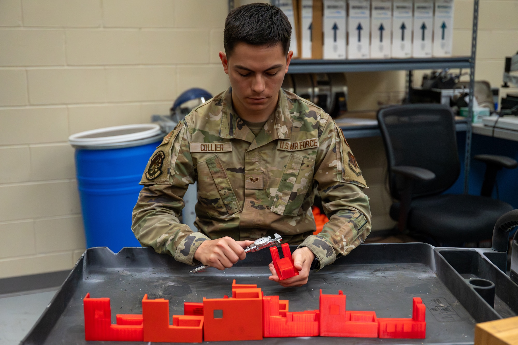 U.S. Air Force Senior Airman Andrew Collier, 325th Maintenance Squadron metals technology journeyman, inspects recently completed 3D-printed covers at Tyndall Air Force Base, Florida, April 22, 2026