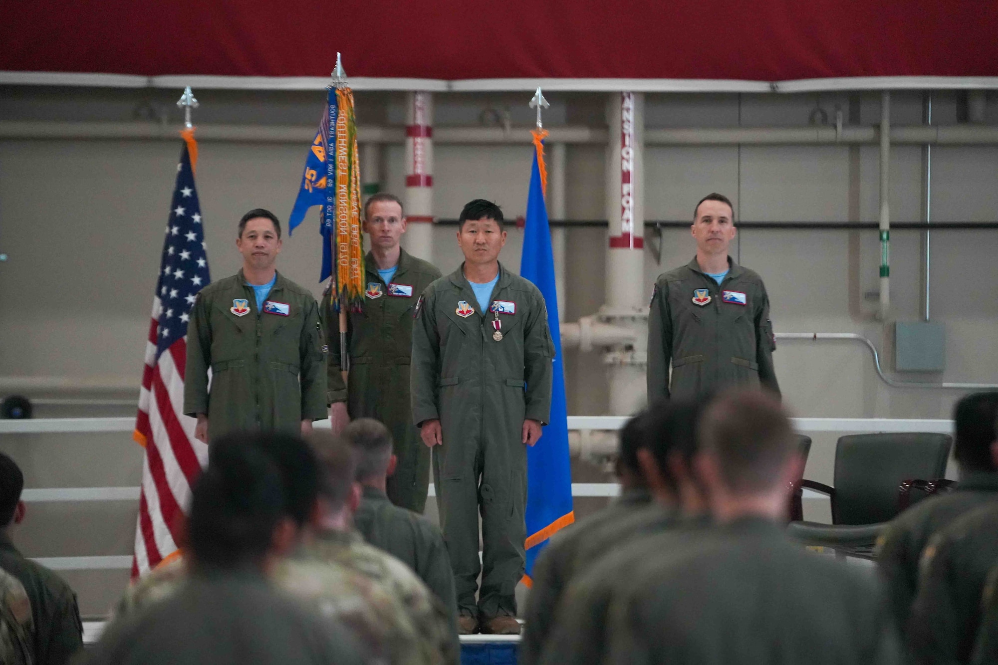 From left, U.S. Air Force Col. Landon Quan, 25th Attack Wing deputy commander of operations, Senior Master Sgt. Brittan Hahn, 11th Attack Squadron senior enlisted leader, Lt. Col. Nathaniel Dull, 11th ATKS outgoing commander, and Lt. Col. Douglas Kottraba, 11th ATKS incoming commander, stand at attention during a change of command ceremony at Creech Air Force Base, Nevada, April 17, 2026.