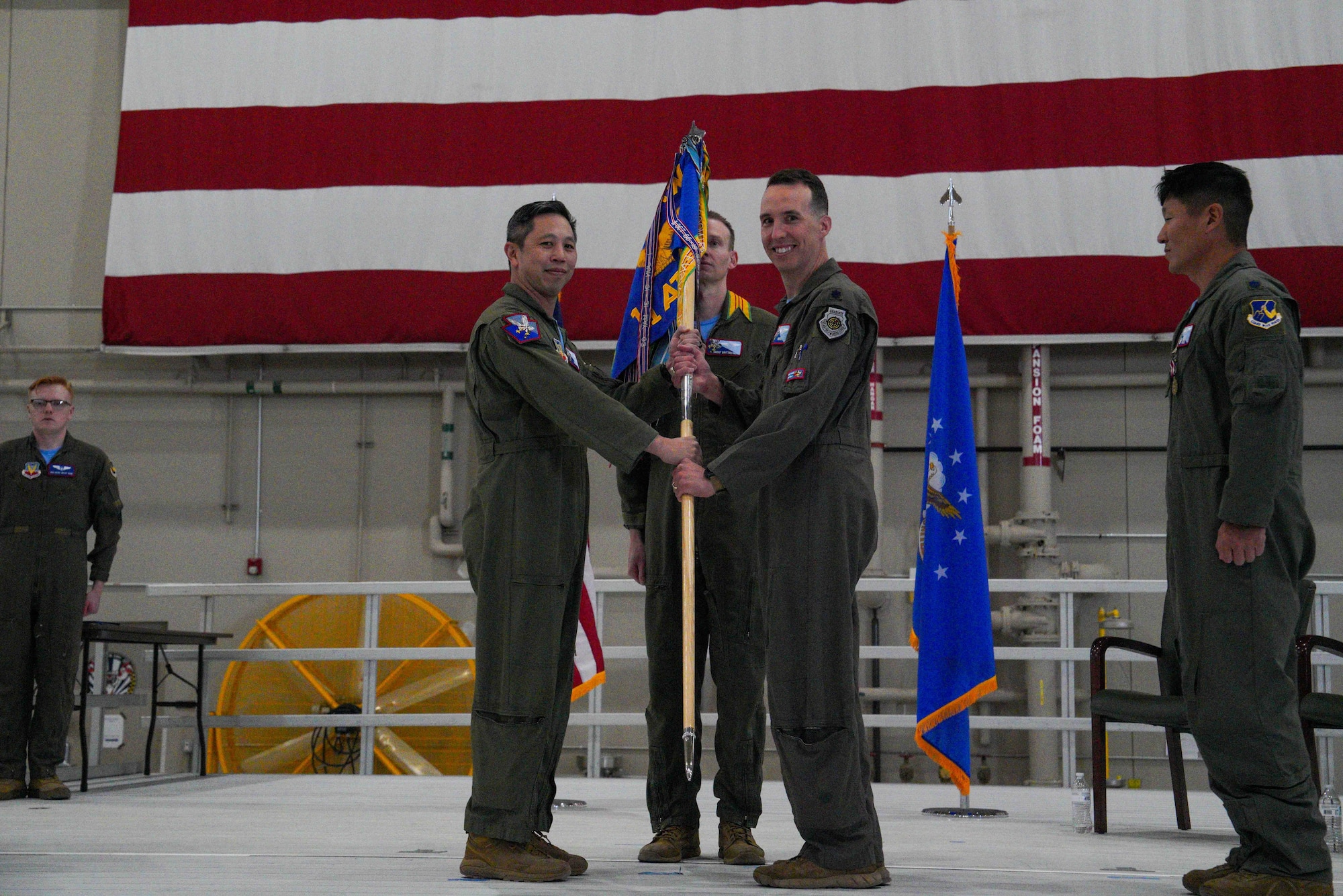 U.S. Air Force Lt. Col. Douglas Kottraba, 11th Attack Squadron incoming commander, assumes command by receiving the squadron guidon from Col. Landon Quan, 25th Attack Wing deputy commander of operations, during a change of command ceremony at Creech Air Force Base, Nevada, April 17, 2026.