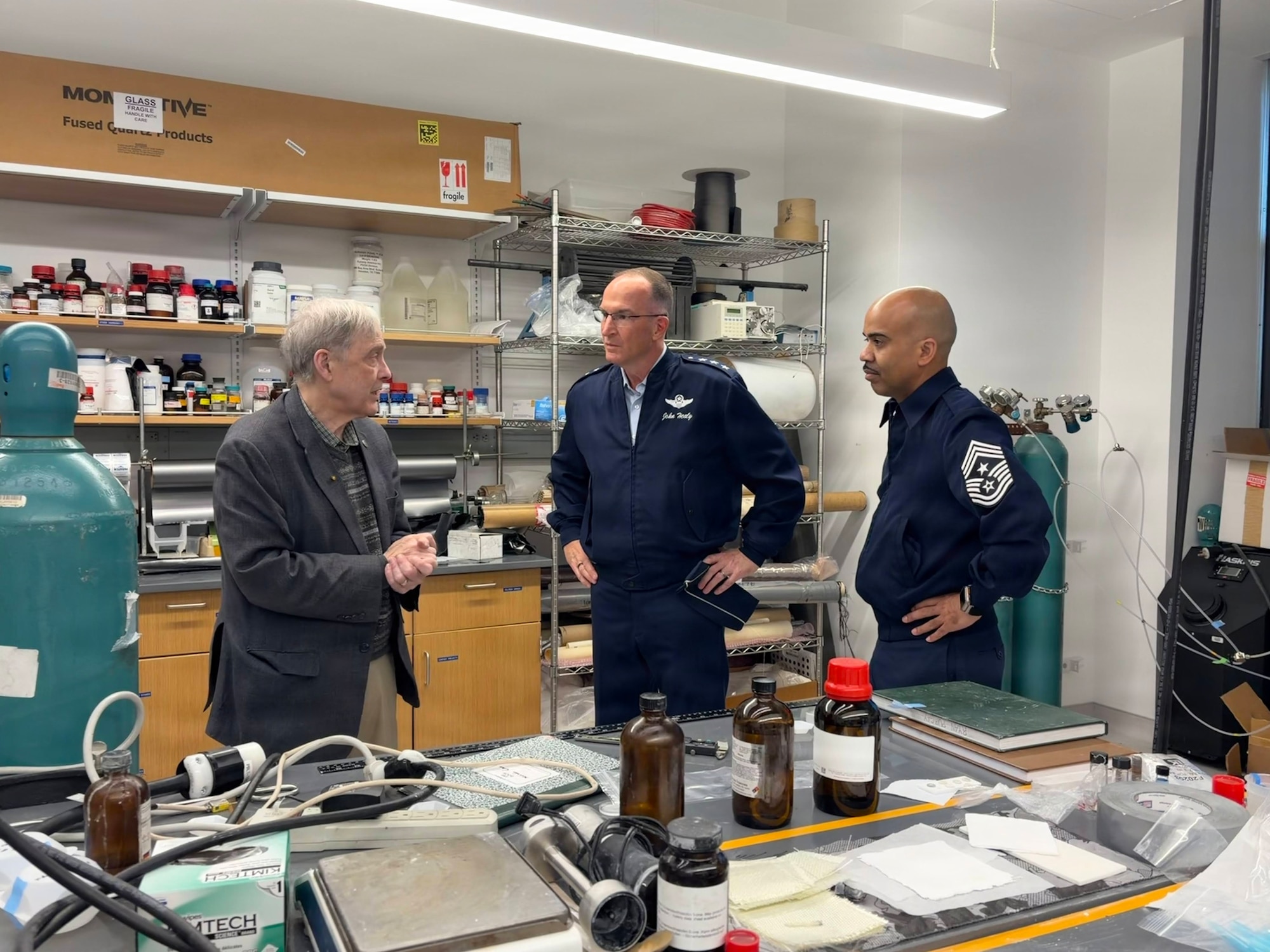 Three people stand in a science lab