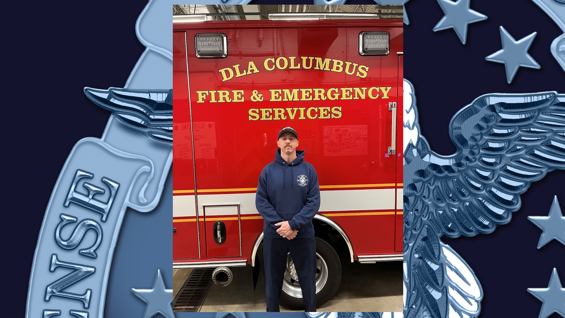 Man wearing blue ball cap and blue pants and shirt standing in front of fire truck