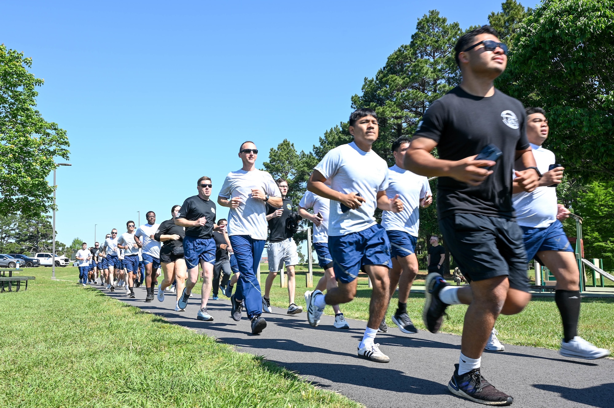 A group of people run in a straight line.