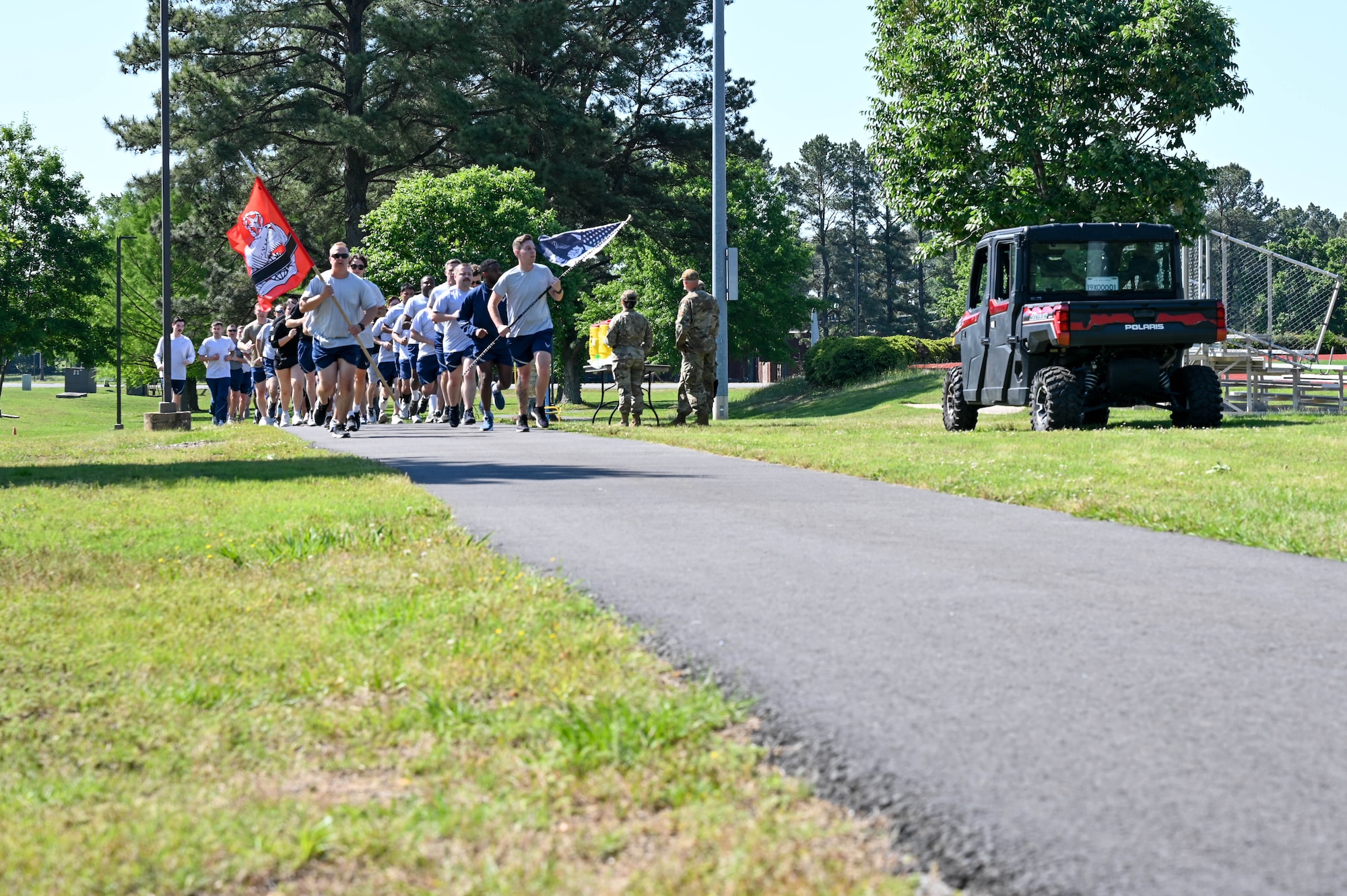 A group of people run in a straight line.