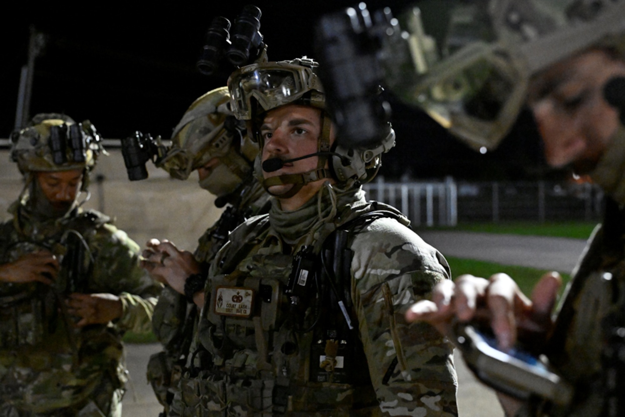 Men stand in military gear.