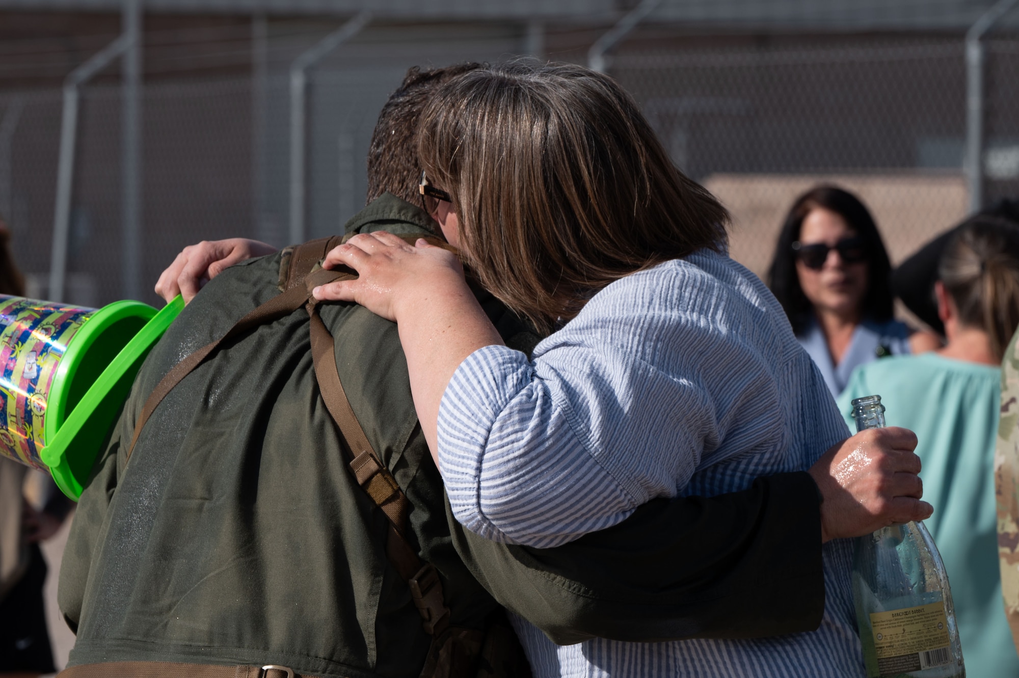U.S. Air Force Col. Charles Redmond, 355th Wing deputy commander, is embraced by his wife after the completion of his “fini” flight at Davis-Monthan Air Force Base, Arizona, May 12, 2026. The fini flight marked the culmination of his flying duties at Davis-Monthan and celebrated his service and leadership within the squadron. (U.S. Air Force photo by Airman Najzee Kuzu)