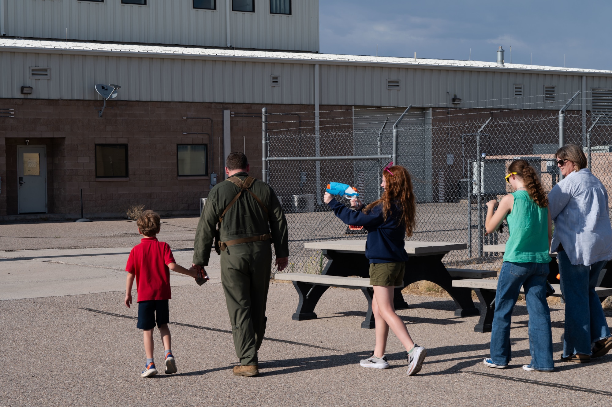 U.S. Air Force Col. Charles Redmond, 355th Wing deputy commander, exits the flightline after his “fini” flight surrounded by his family at Davis-Monthan Air Force Base, Arizona, May 12, 2026. Aircrew members and loved ones gathered to celebrate the occasion and celebrate his accomplishments throughout his career. (U.S. Air Force photo by Airman Najzee Kuzu)