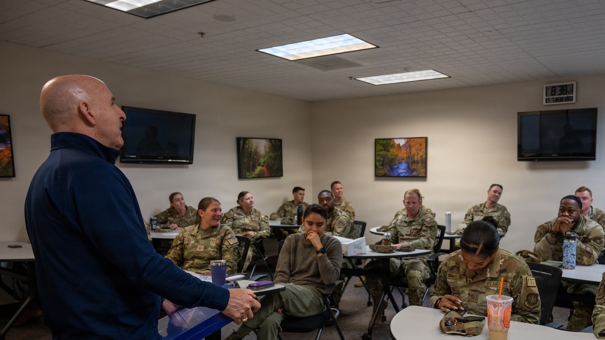 A man talking to a classroom of people.