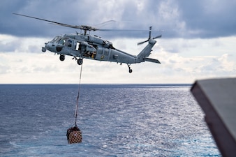 A U.S. Navy MH-60 Sea Hawk assigned to Helicopter Sea Combat Squadron (HSC) 21 delivers supplies from Lewis and Clark-class dry cargo and ammunition ship USNS Alan Shepard (T-AKE 3) onto Wasp-class amphibious assault ship USS Boxer (LHD 4) during a replenishment-at-sea, May 11, 2026.