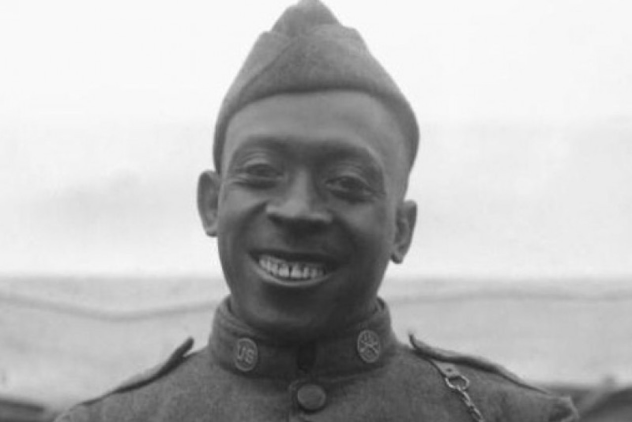 A man, wearing a military uniform, smiles for the camera.