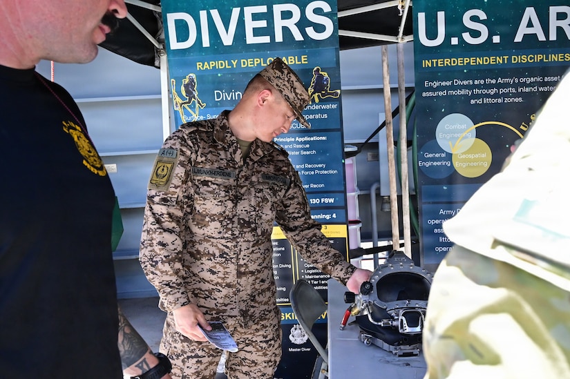 Mongolian Army Command Sgt. Maj. Munkh-Erdene Lkhaasuren inspects a dive helmet used by U.S. Army Combat Divers after receiving a brief during a Senior Enlisted Leader Forum tour of a U.S. Army Logistics Support Vessel, May 12, 2026.