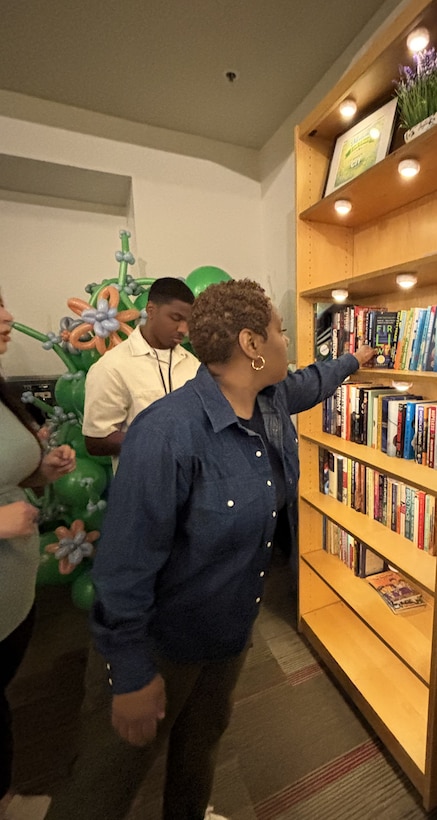 Women reaches for book from shelf.