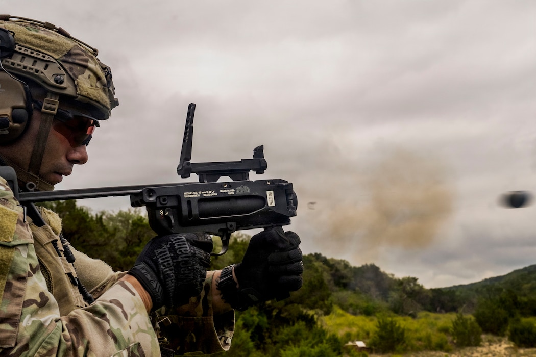 A Tactical Air Control Party Airman assigned to Detachment 2, 6th Combat Training Squadron, fires an M320A1 grenade launcher during heavy weapons training at Joint Base San Antonio-Camp Bullis, Texas, April 23, 2026. The M320A1 is used to engage enemy personnel in bunkers, foxholes and behind obstacles, while also providing illumination, target marking and concealment support for troop movements. (U.S. Air Force photo by Melissa Hydrick)