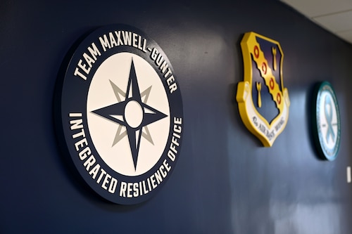 Various shields and emblems hang in the entryway of the Integrated Resilience Center on Maxwell Air Force Base, Alabama, May 15, 2026. The IRC provides Airmen, Guardians, civilian employees and families with coordinated support services on mental, physical, social and spiritual well-being.
