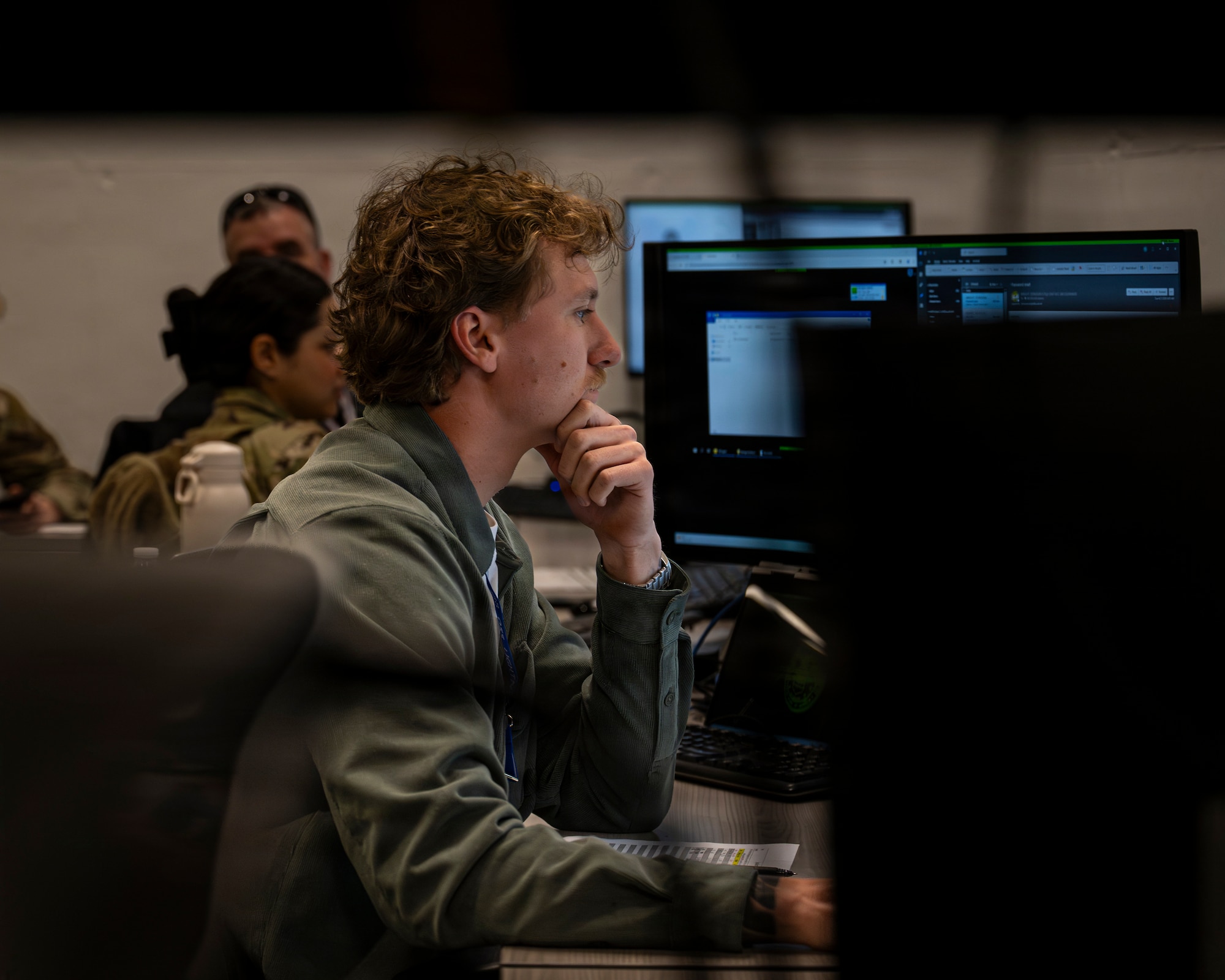 A photo of a man staring intently at a computer screen