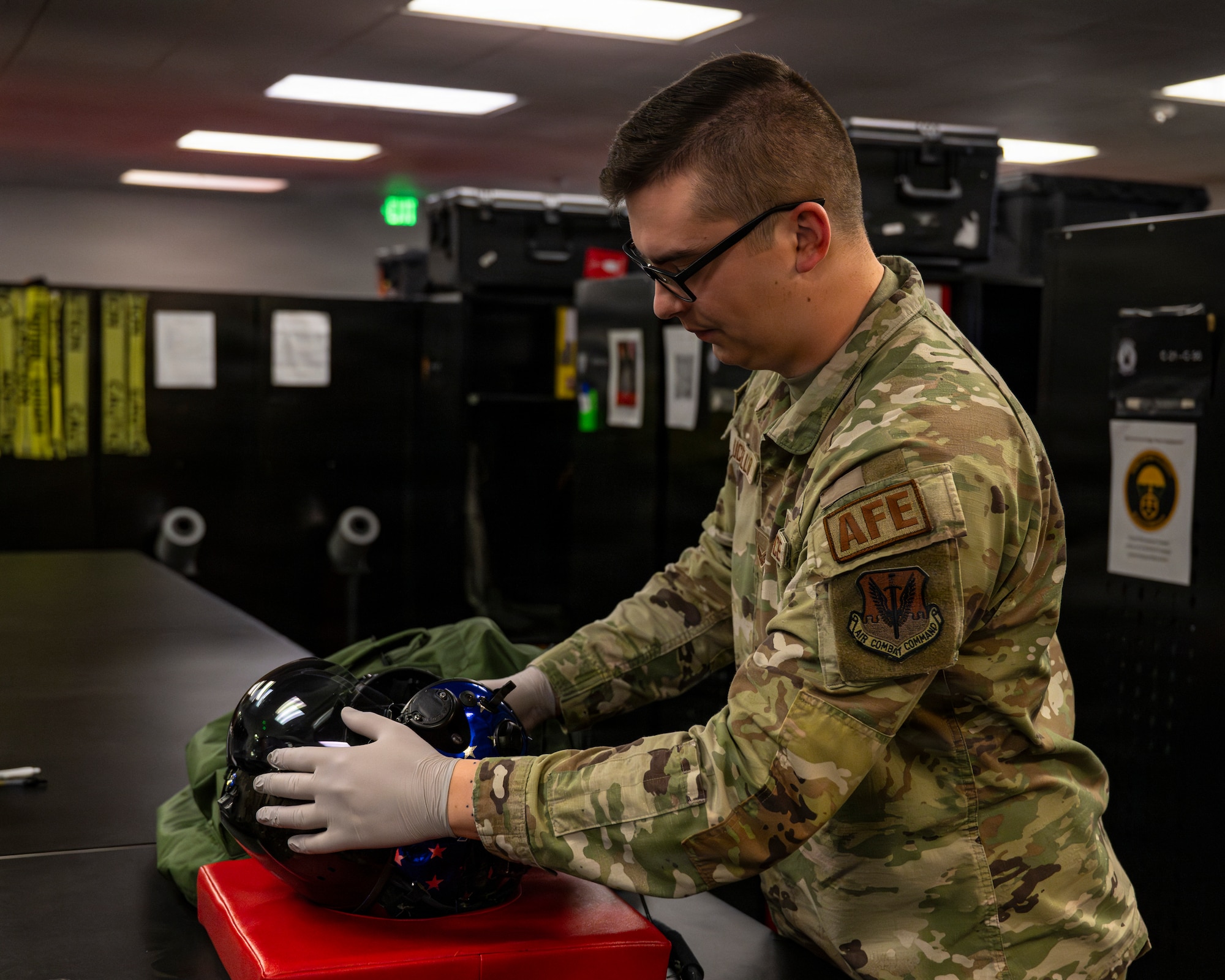 A photo of an Airman inspecting an F-35A Lightning II pilot's helmet