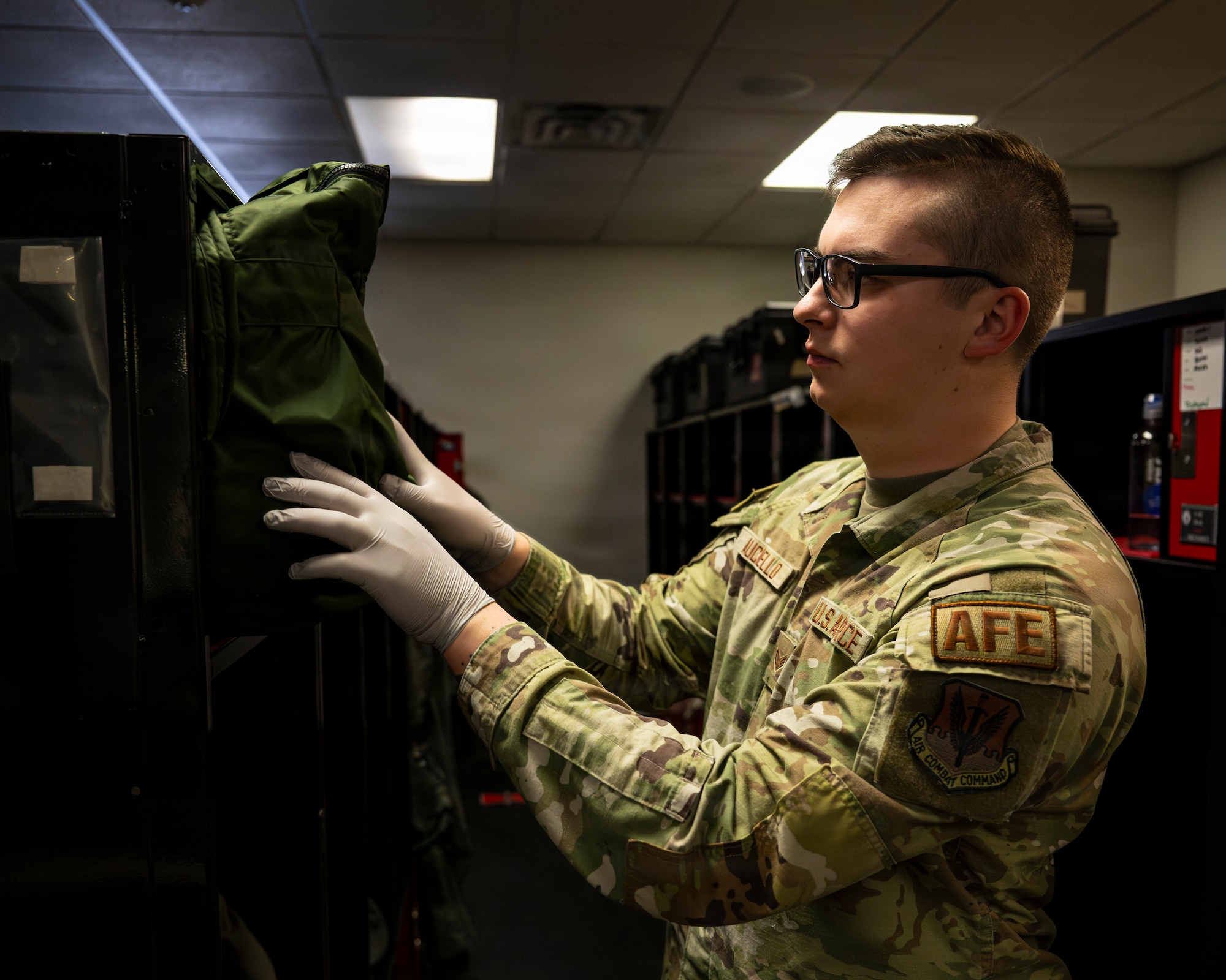 A photo of an Airman inspecting flight gear